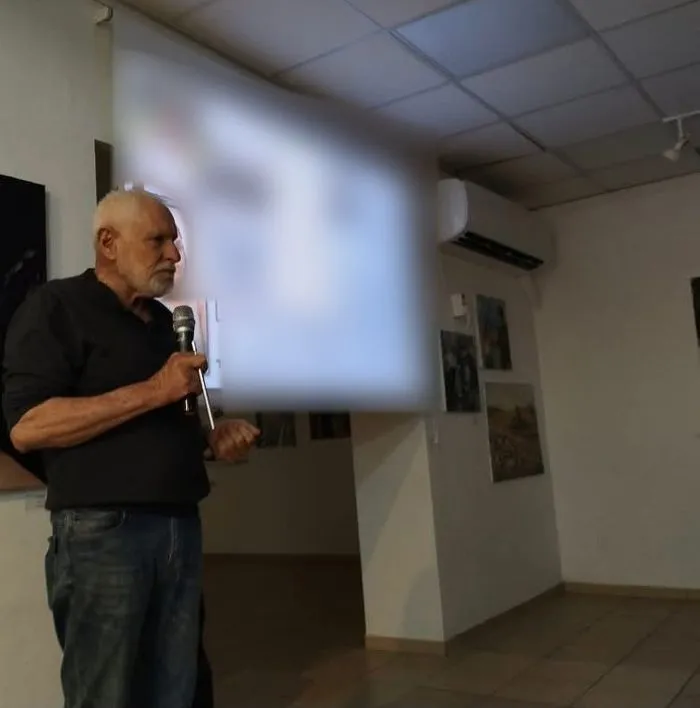 חזי פוזננסקי מרצה עם מיקרופון מול מצגת